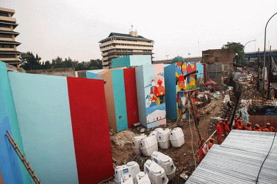 Petugas PPSU membuat mural disalah satu bangunan Kampung Gembira di kawasan Pasar Gembrong, Jakarta Timur, Selasa (13/9/2022).