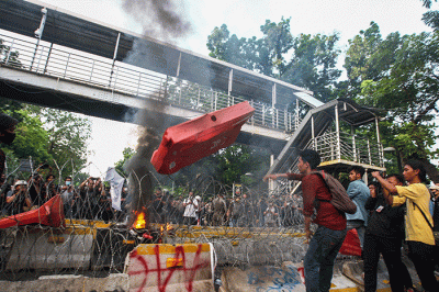 Massa aksi menghindar dari kobaran api saat demo menolak kenaikan BBM di kawasan Patung Kuda, Monas, Jakarta Selasa (13/9/2022).