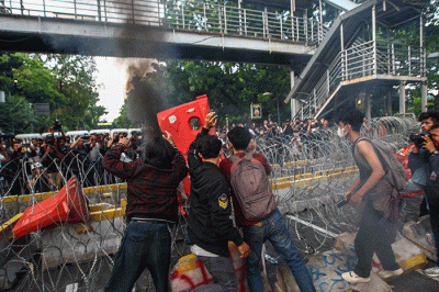 Massa aksi menghindar dari kobaran api saat demo menolak kenaikan BBM di kawasan Patung Kuda, Monas, Jakarta Selasa (13/9/2022).
