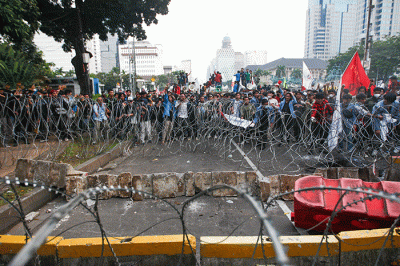 Massa aksi menghindar dari kobaran api saat demo menolak kenaikan BBM di kawasan Patung Kuda, Monas, Jakarta Selasa (13/9/2022).