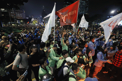Sejumlah pengunjuk rasa berusaha membakar pembatas jalan saat aksi di kawasan Jalan Medan Merdeka Barat, Jakarta, Selasa (13/9/2022).