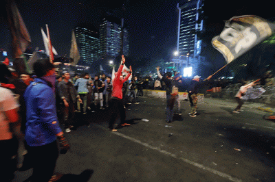 Sejumlah pengunjuk rasa berusaha membakar pembatas jalan saat aksi di kawasan Jalan Medan Merdeka Barat, Jakarta, Selasa (13/9/2022).