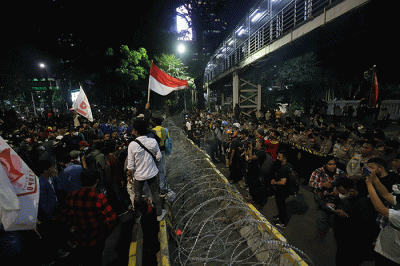Sejumlah pengunjuk rasa berusaha membakar pembatas jalan saat aksi di kawasan Jalan Medan Merdeka Barat, Jakarta, Selasa (13/9/2022).