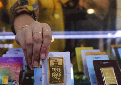 Penjual saat menunjukkan emas logam mulia di Jakarta, Rabu (14/9/2022).