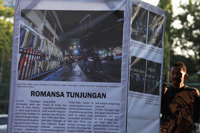Pengunjung mengamati foto cerita karya Unit Kegiatan Mahasiswa (UKM) Communication Photography Club (CIPHOC).