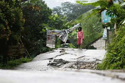 Sejumlah warga melintas di ruas jalan yang rusak akibat bencana tanah bergerak di Desa Bojong Koneng, Bogor, Jawa Barat, Jumat (23/9/2022).