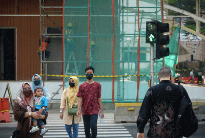Warga tetap menerapkan protokol kesehatan saat berjalan di kawasan Jalan MH Thamrin, Jakarta Pusat, Jumat (23/9/2022).