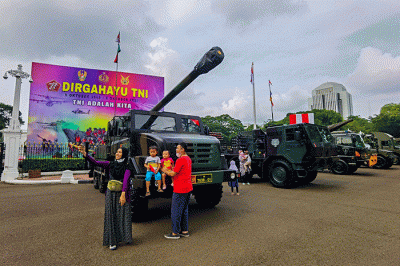 Warga berfoto di depan sejumlah alat utama sistem persenjataan atau alutsista milik TNI yang dipamerkan didepan Istana dan Bundaran Hotel Indonesia.