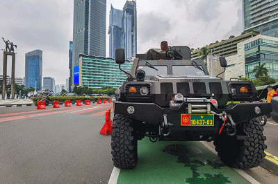 Warga berfoto di depan sejumlah alat utama sistem persenjataan atau alutsista milik TNI yang dipamerkan didepan Istana dan Bundaran Hotel Indonesia.