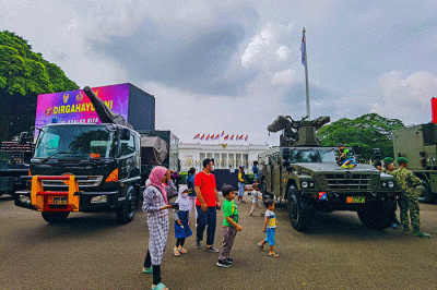 Warga berfoto di depan sejumlah alat utama sistem persenjataan atau alutsista milik TNI yang dipamerkan didepan Istana dan Bundaran Hotel Indonesia.