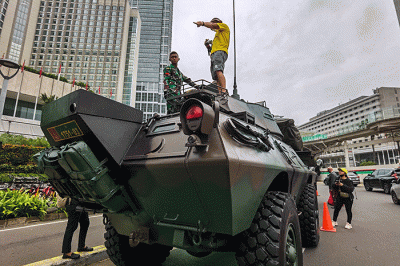 Warga berfoto di depan sejumlah alat utama sistem persenjataan atau alutsista milik TNI yang dipamerkan didepan Istana dan Bundaran Hotel Indonesia.