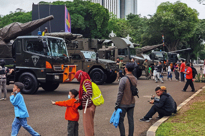 Warga berfoto di depan sejumlah alat utama sistem persenjataan atau alutsista milik TNI yang dipamerkan didepan Istana dan Bundaran Hotel Indonesia.