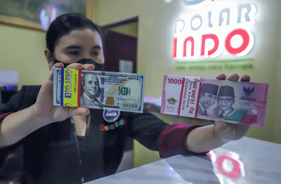 Petugas menunjukkan mata uang Rupiah dan Dolar AS di tempat penukaran uang Dolar Indo, Jakarta, Selasa (11/10/2022).