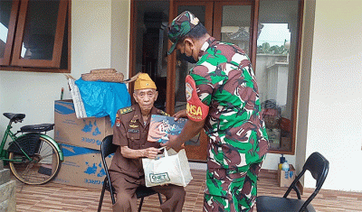 Prajurit TNI dari Kodim 1611 Badung bali memberikan sembako dari Qnet kepada warakawuri dalam acara penyerahan rumah layak huni bagi warakawuri di Badung, Bali.