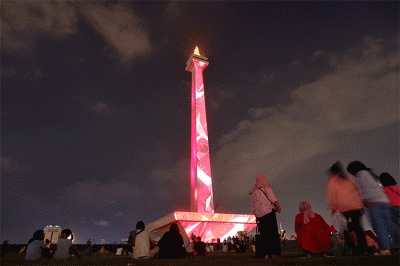 Pengunjung menyaksikan pertunjukkan video mapping dan air mancur menari pada acara Monas Week 2022 di kawasan Monas, Jakarta, Minggu (16/10/2022).