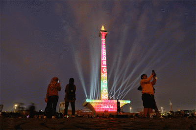 Pengunjung menyaksikan pertunjukkan video mapping dan air mancur menari pada acara Monas Week 2022 di kawasan Monas, Jakarta, Minggu (16/10/2022).