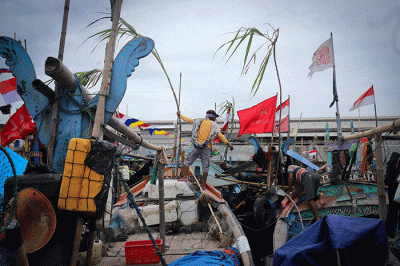Warga menata sesaji diatas perahu jelang Pesta Laut atau Syukuran Laut di kawasan Teluk Cilincing, Jakarta Utara, Jumat (21/10/2022).
