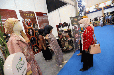 Pengunjung mengamati baju yang dipamerkan saat Jakarta Muslim Fashion Week (JMFW) 2023 di ICE, BSD City, Banten, Kamis (20/10/2022).