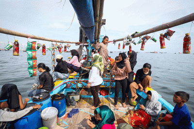 Sejumlah warga mengikuti proses pelepasan sesaji ke laut saat tradisi Nadran Pesta Laut atau Festival Kampung Nelayan di Cilincing, Jakarta Utara.