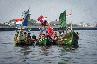 Sejumlah warga mengikuti proses pelepasan sesaji ke laut saat tradisi Nadran Pesta Laut atau Festival Kampung Nelayan di Cilincing, Jakarta Utara.