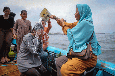 Sejumlah warga mengikuti proses pelepasan sesaji ke laut saat tradisi Nadran Pesta Laut atau Festival Kampung Nelayan di Cilincing, Jakarta Utara.