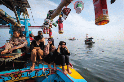 Sejumlah warga mengikuti proses pelepasan sesaji ke laut saat tradisi Nadran Pesta Laut atau Festival Kampung Nelayan di Cilincing, Jakarta Utara.