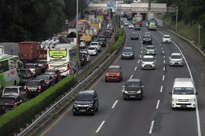 Warga mengamati lalu lintas tol jorr di kawasan Jatiwarna, Kota Bekasi, Jawa Barat, Rabu (26/10/2022).
