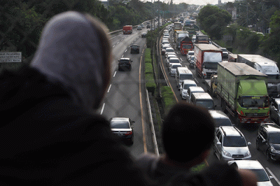Warga mengamati lalu lintas tol jorr di kawasan Jatiwarna, Kota Bekasi, Jawa Barat, Rabu (26/10/2022).