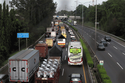 Warga mengamati lalu lintas tol jorr di kawasan Jatiwarna, Kota Bekasi, Jawa Barat, Rabu (26/10/2022).
