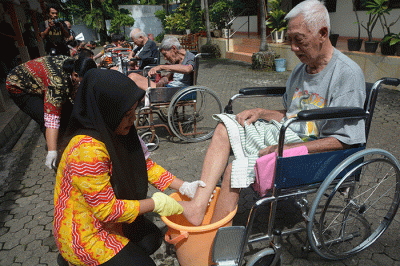 Sejumlah karyawan membasuh kaki 25 orang tua lanjut usia (lansia) atau biasa disebut Oma Opa di halaman Panti Werda Pengayoman, Semarang.