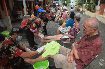 Sejumlah karyawan membasuh kaki 25 orang tua lanjut usia (lansia) atau biasa disebut Oma Opa di halaman Panti Werda Pengayoman, Semarang.