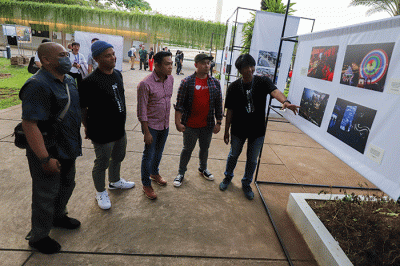 Pengunjung melihat pameran foto Rekam Jakarta 24+ di Lapangan Banteng, Jakarta Pusat, Jumat (28/10/2022).