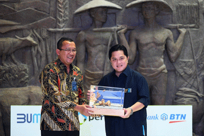 Direktur Utama Bank BTN Haru Koesmahargyo (kiri) memberikan Buku Kajian Perumahan kepada Menteri BUMN Erick Thohir saat peluncuran Festival KPR Hunian Pemuda.
