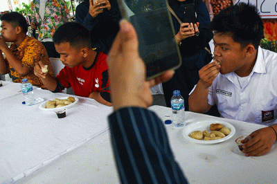 Pelajar yang menjadi peserta lomba makan pempek dos adu cepat dan banyak menghabiskan 10 buah pempek yang disiapan panitia dengan waktu 60 detik.