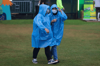Penonton mengenakan jas hujan saat menyaksikan acara Joyland Festival 2022 di GBK Softball Stadium, Senayan, Jakarta, Jumat (4/11/2022).