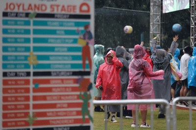 Penonton mengenakan jas hujan saat menyaksikan acara Joyland Festival 2022 di GBK Softball Stadium, Senayan, Jakarta, Jumat (4/11/2022).