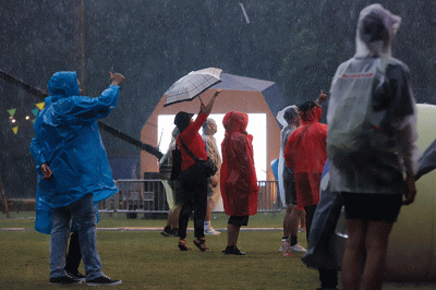 Penonton mengenakan jas hujan saat menyaksikan acara Joyland Festival 2022 di GBK Softball Stadium, Senayan, Jakarta, Jumat (4/11/2022).