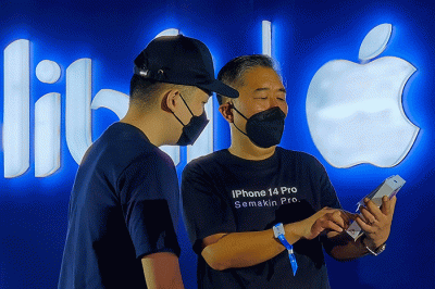 CEO Blibli Kusumo Martanto (kanan) menyerahkan seri iPhone 14 Pro ke pelanggan pertama saat Midnight Lounge di Jakarta, Jumat (4/11/2022).