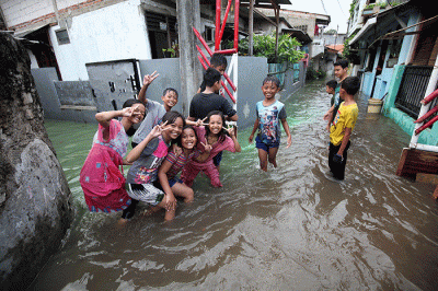 Anak-anak bermain banjir yang menggenangi Jalan Swadarma Raya, Petukangan, Jakarta, Sabtu (5/11/2022).