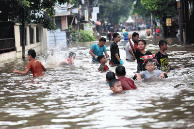Anak-anak bermain banjir yang menggenangi Jalan Swadarma Raya, Petukangan, Jakarta, Sabtu (5/11/2022).