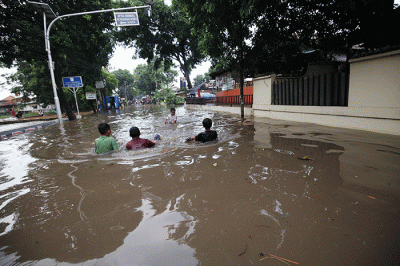 Anak-anak bermain banjir yang menggenangi Jalan Swadarma Raya, Petukangan, Jakarta, Sabtu (5/11/2022).