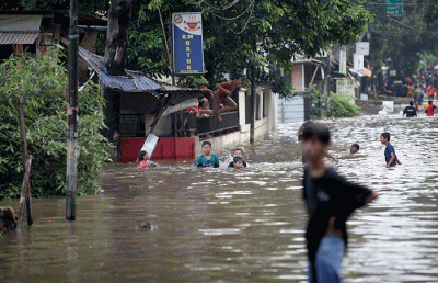 Anak-anak bermain banjir yang menggenangi Jalan Swadarma Raya, Petukangan, Jakarta, Sabtu (5/11/2022).
