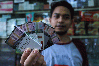 Penjual menunjukkan beberapa merek rokok di Jakarta, Sabtu (5/11/2022).
