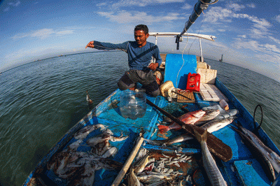 Nelayan mengganti oli mesin Mesran Super pada perahunya di Pulau Gusung, Makassar, Minggu (6/11/2022).