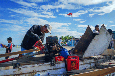 Nelayan mengganti oli mesin Mesran Super pada perahunya di Pulau Gusung, Makassar, Minggu (6/11/2022).