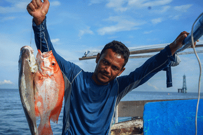 Nelayan mengganti oli mesin Mesran Super pada perahunya di Pulau Gusung, Makassar, Minggu (6/11/2022).