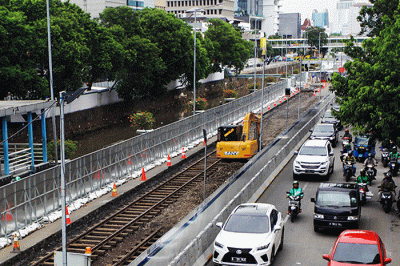 Seorang warga melihat rel trem peninggalan zaman Belanda dari JPO Gajah Mada, Jakarta, Senin (7/11/2022).
