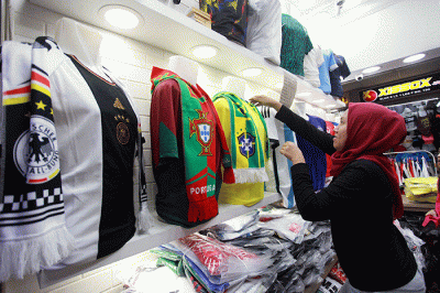 Pedagang menunjukan kostum tim sepak bola peserta Piala Dunia 2022 Qatar di salah satu kios di Blok B Pasar Tanah Abang, Jakarta, Sabtu (19/11/2022).