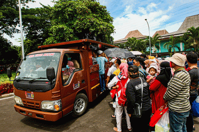 Sejumlah pengunjung mengantre menaiki bus wisata keliling di Taman Mini Indonesia Indah (TMII), Jakarta, Minggu (20/11/2022).
