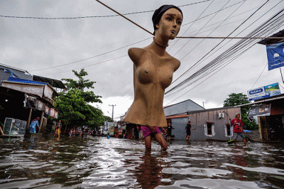 Warga melintasi banjir yang mengenangi Jalan Nipa-nipa di Kecamatan Manggala, Makassar, Sulawesi Selatan, Minggu (20/11/2022).